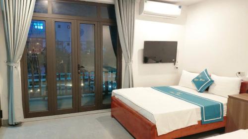a bedroom with a bed and a balcony with a television at Tam Cốc Diện Hoa Hotel & Restaurant in Văn Lâm