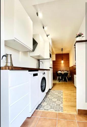 a kitchen with white cabinets and a washer and dryer at Estavar in Estavar