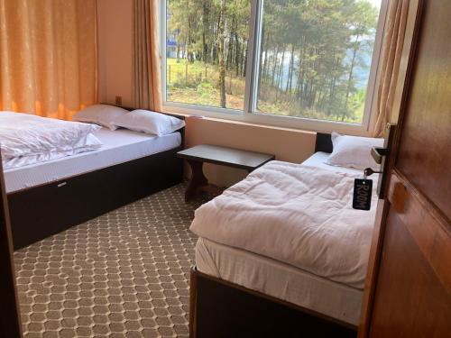 a small room with two beds and a window at Hotel New Manakamana in Pāti Bhanjyāng