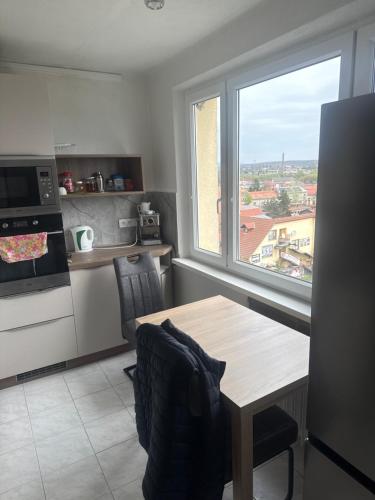 a kitchen with a table and a large window at Apartment Centrum in Lučenec