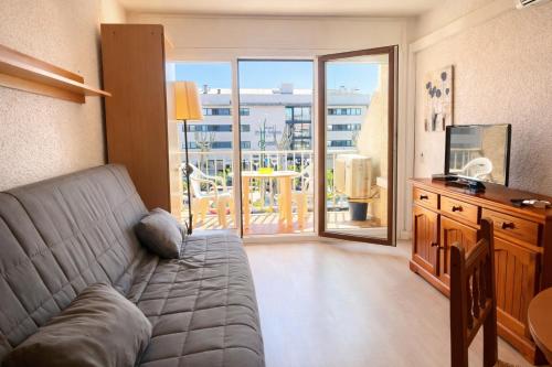 a living room with a couch and a balcony at Basic Comfort Studio Poblat tipic 0167 in Empuriabrava