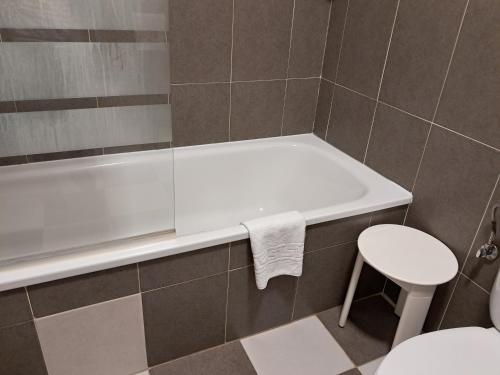 a bathroom with a tub and a toilet and a stool at La orilla del sella in Cangas de Onís