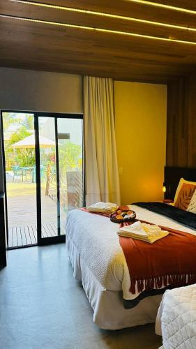 a bedroom with two beds and a sliding glass door at Pousada Gaucha in Fernando de Noronha