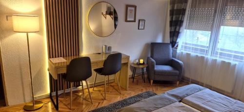 a bedroom with a bed and a desk and chairs at House Dado in Jezerce