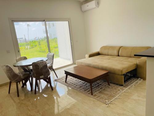 a living room with a couch and a table at Apparemment s1 vu sur mer et piscine in Zarzis