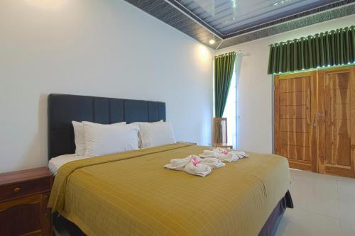 a bedroom with a bed with two towels on it at Pohon Purba Resort & Restaurant in Pulau Lebur