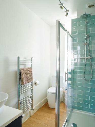 a bathroom with a toilet and a glass shower at Finest Retreats - Centre View in Sidmouth