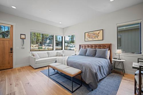 a bedroom with a bed and a couch and windows at 18171-2 Forestbrook Loop in Bend