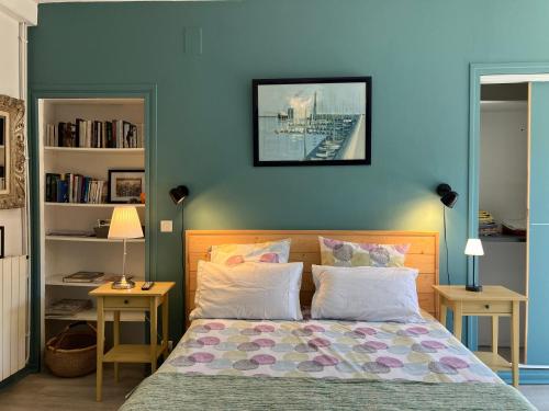 a bedroom with a bed with a blue wall at La cerisaie in Montpellier
