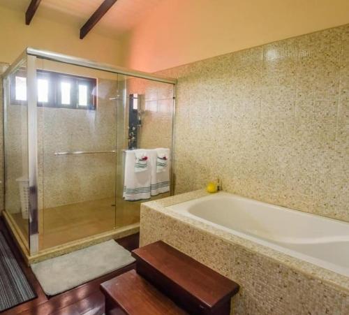 a bathroom with a large tub and a glass shower at Careffe Escape Hideaway in Monchy