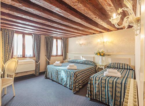 a hotel room with two beds and a table and chairs at Hotel Castello in Venice