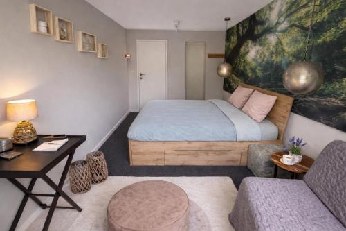 a bedroom with a bed and a table and a couch at Landgoed Rotermundt in Huijbergen