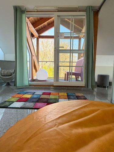 a bedroom with a bed and a large window at Design Ferienhaus Kamerun an der Elbe in Damnatz