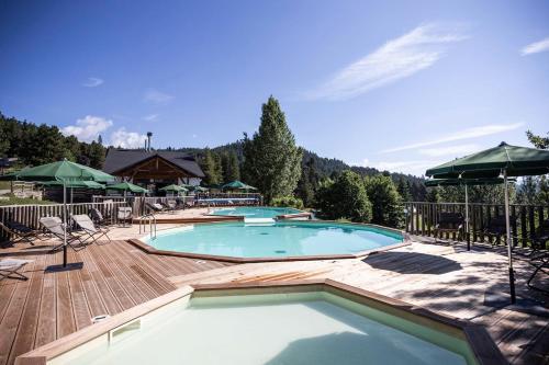a large swimming pool on a wooden deck at Huttopia Font Romeu in Font-Romeu