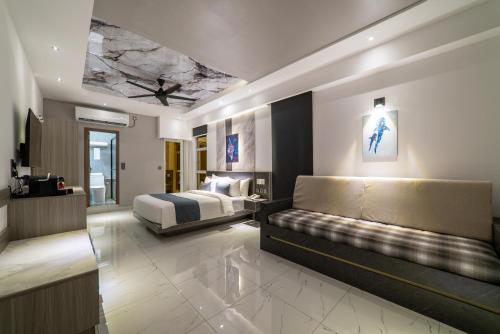 a hotel room with a bed and a couch at Samann Blue in Hulhumale