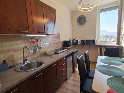 a kitchen with a sink and a table with chairs at Panoráma 4U in Tapolca
