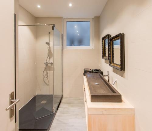 a bathroom with a sink and a shower at Le Blue Note intra-muros - Bel appartement de standing in Saint Malo