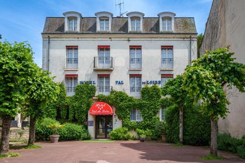 a large white building with a red awning at Hotel Val De Loire in Azay-le-Rideau