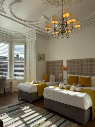 a bedroom with two beds and a chandelier at Edinburgh37 in Edinburgh