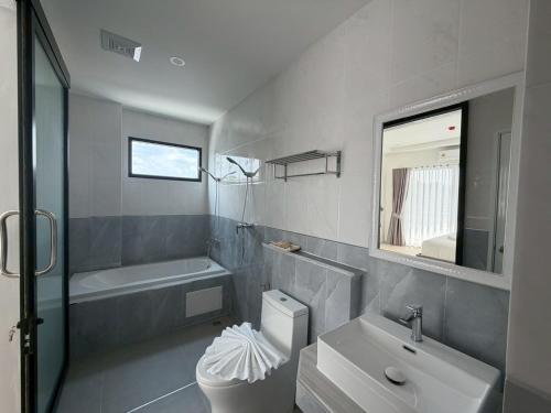 a bathroom with a sink and a toilet and a mirror at The View Hotel โรงแรมเดอะวิว นครศรีธรรมราช in Nakhon Si Thammarat