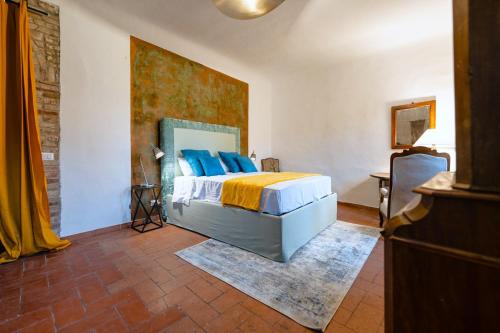 a bedroom with a bed with blue pillows at Il Nido dell'Oca - Loft Giardino in Siena