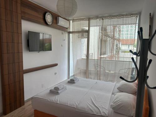 a bedroom with a bed and a window with a clock at Old Town Apart in Budva