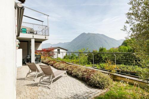 a patio with chairs and a view of a mountain at EASYLIFE - Como - Crotta 3 - Argegno in Argegno