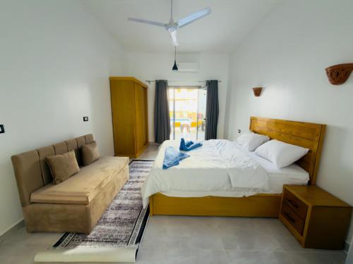 a bedroom with a bed and a couch at Azure Guest House in Luxor