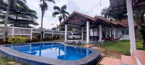 a swimming pool in front of a house at Villa Ananda 1, 3 KT Kolam Renang, Karaoke Biliar in Cisarua