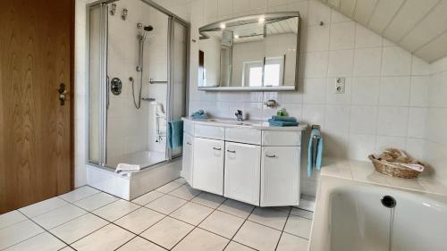 a bathroom with a sink and a shower and a tub at Wiesenhaus, Ferienhaus in Manderscheid