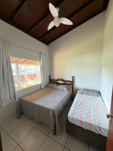 a bedroom with two beds and a ceiling fan at Rancho Renato Chaveiro in Capitólio
