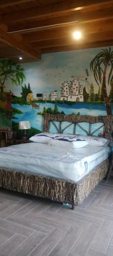 a bed in a room with a painting on the wall at Rivana Inn - ريفانا in ‘Izbat an Nāmūs