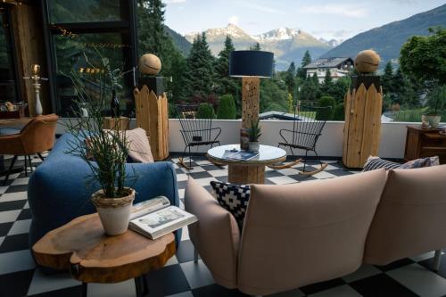 a living room with couches and tables and mountains at Sendlhofer's in Bad Hofgastein