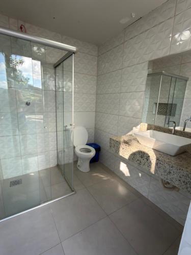 a bathroom with a shower and a toilet and a sink at Rancho Renato Chaveiro in Capitólio