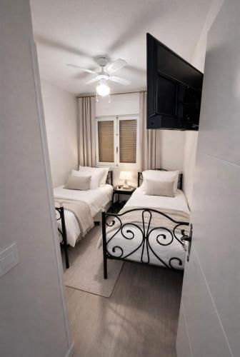 a bedroom with two beds and a flat screen tv at Casa Claudia&Simon in Santa Pola