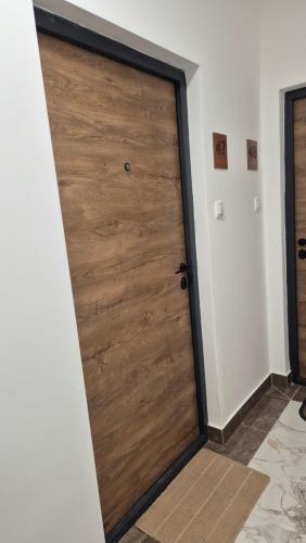 a wooden door in a room with a wall at Silver Marina Residence in Veliko Gradište