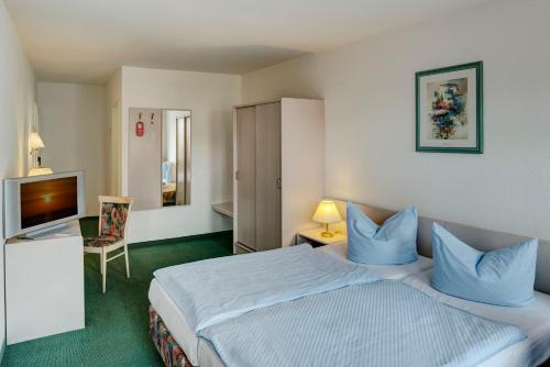 a hotel room with a bed and a television at Hotel zum Kater in Rostock