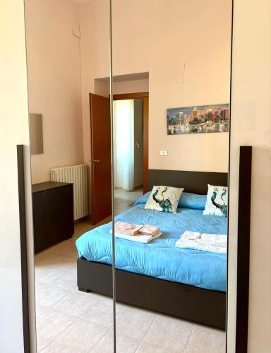 a bedroom with a blue bed and a mirror at Corso Ovidio - Casa vacanze in Sulmona