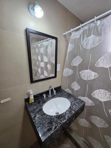 a bathroom with a sink and a shower curtain at Departamento Alberdi in San Pedro de Jujuy