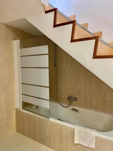 a bathroom with a bath tub under a staircase at Hostal Ruiz in Soria