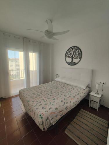a bedroom with a bed with a tree picture on the wall at Apartamento luminoso a 100mts playa, ambiente tranquilo in L'Escala