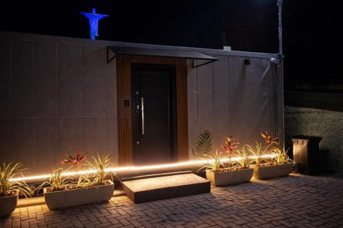 a building with a door with plants and lights at Casa Container Mirante do Cristo in Foz do Iguaçu