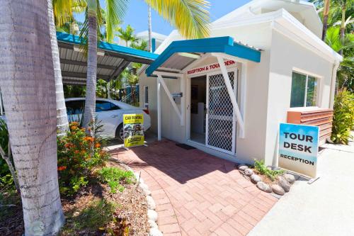 a house with a tour desk sign in front of it at Trinity Beach Pacific in Trinity Beach