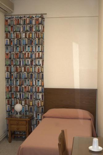 a bedroom with two beds and a wall with a curtain at Hostal Casa Juan in Lorca