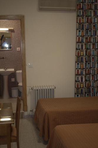 a hotel room with two beds and a bathroom at Hostal Casa Juan in Lorca