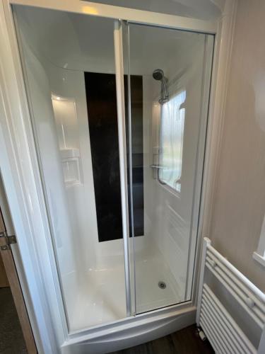 a shower with a glass door in a bathroom at Static in Peak District Ashbourne Heights Derbyshire Play Park Indoor Pool in Tissington