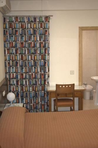 a bedroom with a bed and a table and a curtain at Hostal Casa Juan in Lorca