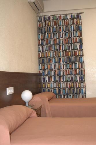 a hotel room with two beds and a curtain with a window at Hostal Casa Juan in Lorca