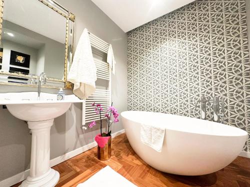 a bathroom with a white tub and a sink at Mondello Luxury villa in Palermo