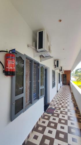 a hallway with a tile floor in a building at Amirtham Holiday Home in Kovakulam